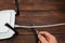 A man with a knife cuts a LAN cable connected to a router on a dark wooden background.