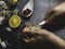 A man with a knife opens a fresh oyster. Dark stone background with lemon, ice, berries, selective focus