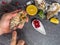 A man with a knife opens a fresh oyster. Dark stone background with lemon, ice, berries, selective focus