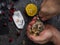 A man with a knife opens a fresh oyster. Dark stone background with lemon, ice, berries, selective focus