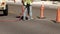 Man laborer working with a jackhammer on the asphalt of a city street uses his foot to position the machine before continuing his