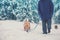 A man with a Labrador retriever dog walks in deep snow