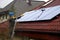 A man on a ladder cleaning solar panels