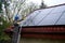 A man on a ladder cleaning solar panels