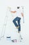 Man on ladder painting with roller