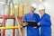 Man and lady in factory looking at clipboard