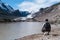 Man by lake looking at Alpine glacier