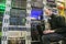 A man with a laptop sits in the server room of the data center. The system administrator works near the racks with the servers.