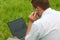 Man with laptop sitting in grass