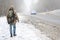 A man with a large backpack walks along a suburban asphalt road