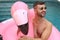 Man in large inflatable pink flamingo