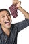 Man laughing and eating grapes