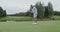 A man launches a golf ball into the hole and pulls the ball out of the hole