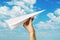 A man launches a paper plane into the sky. Hand with a toy airplane