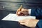 Man lawyer or official signs documents with a pen