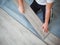 A man is laying laminate flooring. The repair process in the room