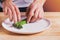 Man laying out steamed green asparagus on the plate, preparing food presentation