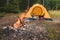 Man laying in tent with smartphone near campfire. hiking concept