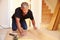 Man laying wood panel flooring during a house refurbishment