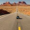 Man lays in the center of a highway in Monument valley