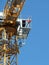 Man leaning over the edge of a high crane platform