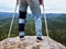 Man with leg in knee cages and crutches for stabilization stay on rock. Hurt tourist walk in mountains
