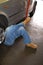 Man With Legs Crossed Working Under a Car