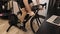 Man legs are cycling indoors on stationary bicycle. Cyclist is doing fitness cardio workout on indoor smart cycling trainer. Male