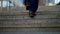 man legs are going up over stone stairs in city, closeup view, elegant shoes and pants