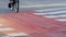 Man legs pedaling city crosswalk red cycling path closeup. Urban traveler riding