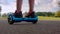 Man legs riding on self balancing board. Closeup of gyro scooter on asphalt road