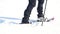 Man legs with snowshoes walk in snow. Detail of winter hike in snowdrift, snowshoeing with trekking poles and shoe cover in powder