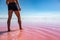 Man legs view walking in pink salt lake water