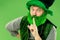 A man in a leprechaun hat at studio. He celebrates St. Patrick`s Day.