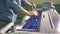 A man is leveling blue paint in a tray of a printing machine