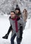Man lifting girl in snow in forest