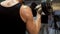 Man lifting heavy dumbbells in front of mirror at gym, personal fitness program