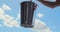 Man lifts Leaking bucket with water dripping, blue sky clouds, Lost opportunity.