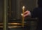 A man lighting a candle in the church