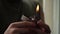 man lights a gasoline lighter while sitting in a room