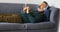 Man listening to music on mobile phone while lying on sofa 4k