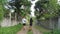 Man with little baby and young woman walk along village road