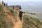 Man living in Sapa, in north Vietnam, carrying a bamboo stake walking in a narrow path in the mountains of Sapa