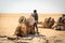 Man loading salt bricks on a camel