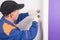 A man, a locksmith, repairs the lock of the front door, close-up