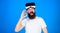 Man with long beard and funny face showing OK gesture. Hipster with trendy beard wearing VR goggles, digital