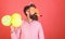 Man with long beard on red background. Bearded man in huge glasses with party whistle, celebration concept. Crazy man