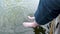 Man in long shorts dangles his legs in the water of lake. splashing water