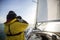 Man Looking Through Binoculars While On Sail Boat