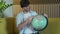 Man looking for countries on globe at home in living room on sofa. Cheerful man holding a geographic globe